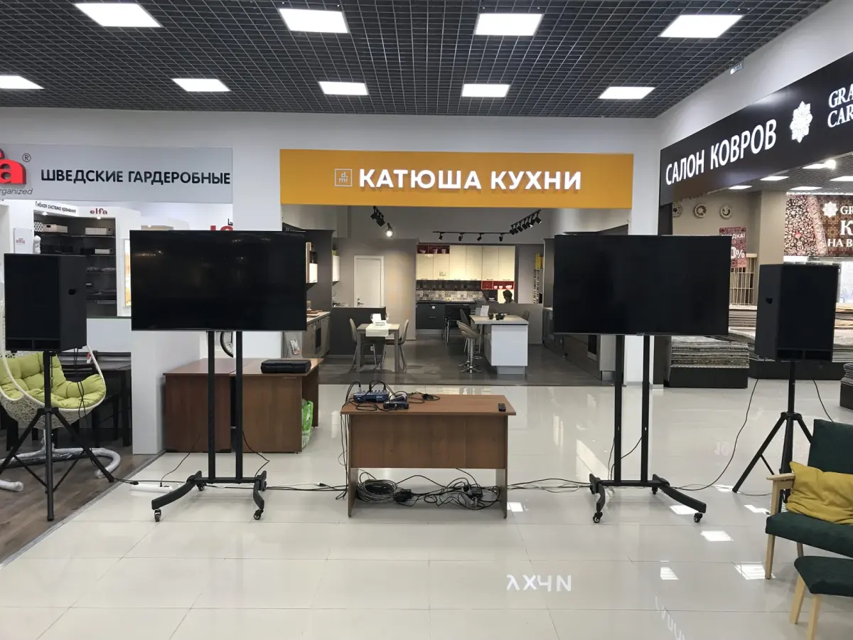 Телевизоры на стойках и акустика на презентации в торговом центре